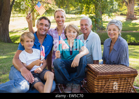 Happy family in the park and holding american flag Stock Photo