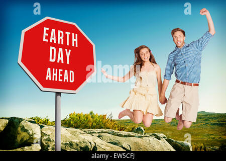 Composite image of cheerful young couple jumping Stock Photo