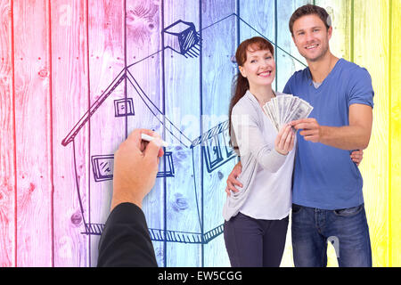 Composite image of couple holding fan of cash Stock Photo