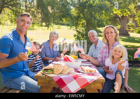 Happy family having picnic and holding american flag Stock Photo