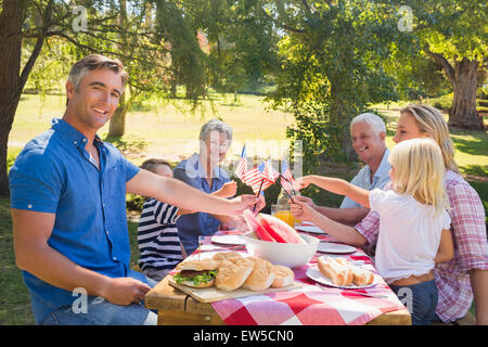 Happy family having picnic and holding american flag Stock Photo