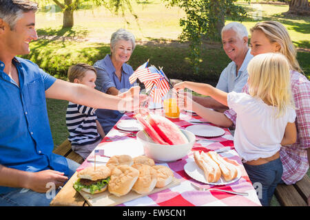 Happy family having picnic and holding american flag Stock Photo