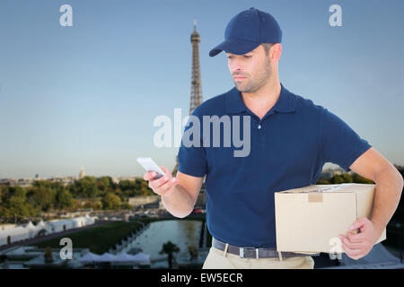 Composite image of delivery man using mobile phone while holding package Stock Photo