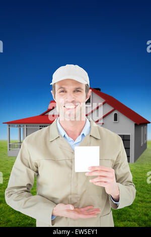 Composite image of happy delivery man showing blank note Stock Photo