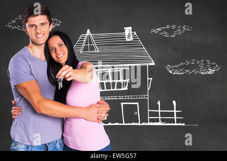 Composite image of young couple showing keys to house Stock Photo