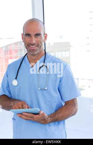 Smiling doctor using tablet computer Stock Photo