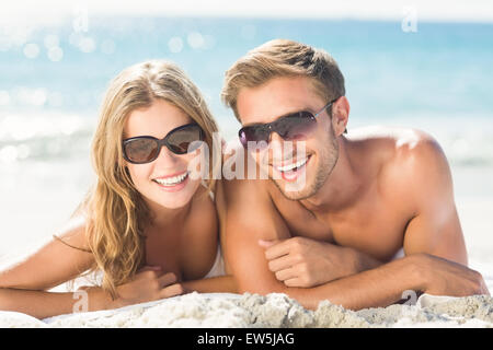 Happy couple relaxing together in the sand Stock Photo
