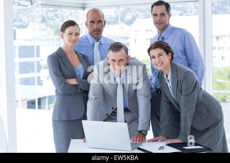 Business team working happily together on laptop Stock Photo