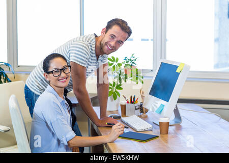 Smiling partners working together on computer Stock Photo