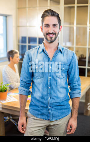 Smiling man looking at camera with his partner behind Stock Photo