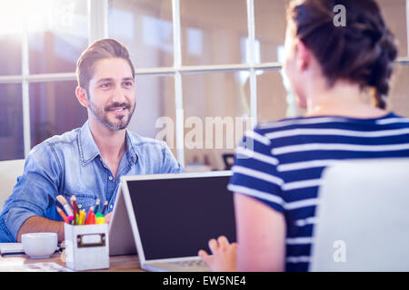 Happy creative workers sharing desk Stock Photo