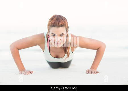Beautiful brunette doing push ups Stock Photo