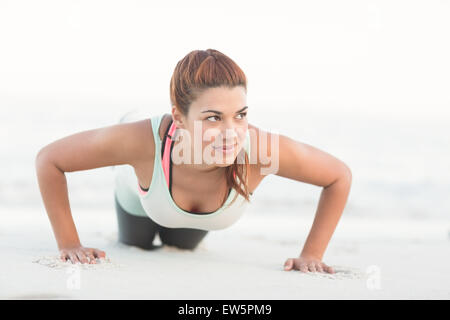 Beautiful brunette doing push ups Stock Photo