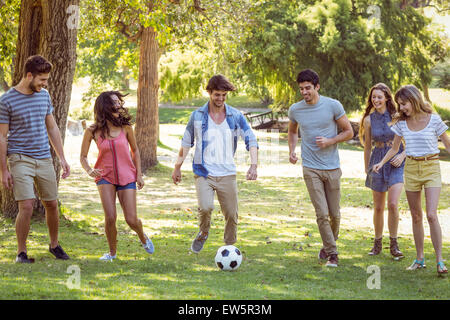 Happy friends in the park with football Stock Photo
