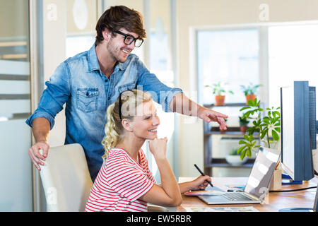 Smiling team working with digitizer and laptop Stock Photo