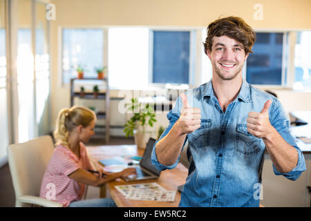 Smiling businessman posing with his partner behind him Stock Photo