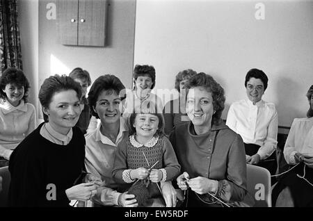 Four-year-old Ruth Malton gets the needles clicking to raise money for a specialist computer for a new blind unit. From the left are Mrs Eileen Hamer, Mrs Margaret Malton and Mrs Sheila Green, who were among 17 Huddersfield Royal Infirmary staff and frien Stock Photo