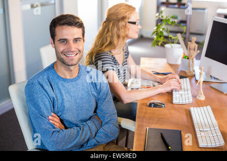 Smiling partners sitting together at desk Stock Photo