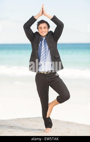 Happy businessman doing yoga Stock Photo
