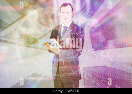 Composite image of serious charismatic businessman holding a tablet computer Stock Photo