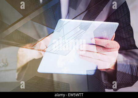 Composite image of businessman scrolling on his digital tablet Stock Photo