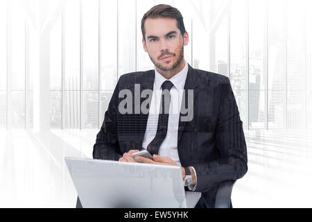 Composite image of cheerful businessman with laptop using smartphone Stock Photo