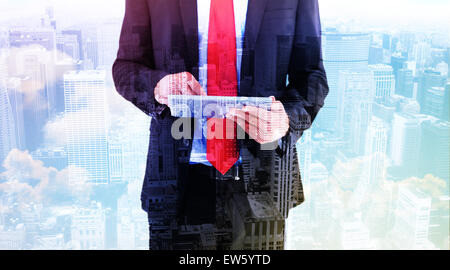 Composite image of businessman scrolling on his digital tablet Stock Photo