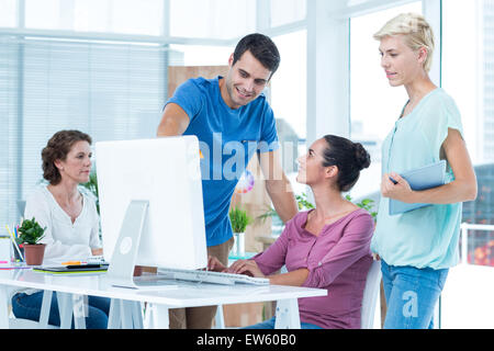 Three casual colleagues using computer Stock Photo
