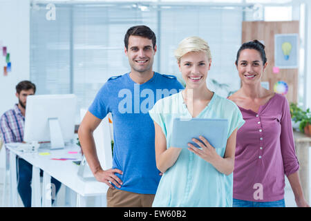 Three casual colleagues using digital tablet Stock Photo