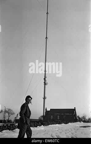 Emley Moor transmitting station mast the day before it collapsed. Falling ice was a regular problem in winter, with people working nearby wearing crash helmets to protect themselves from falling ice. On the 19th March 1969, a combination of strong winds a Stock Photo