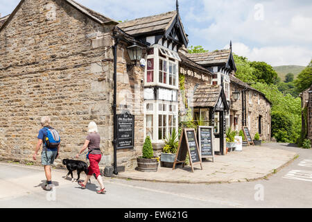 Walkers passing by The Old Nag's Head pub, at the start of the Pennine Way, Edale, Derbyshire, England, UK Stock Photo