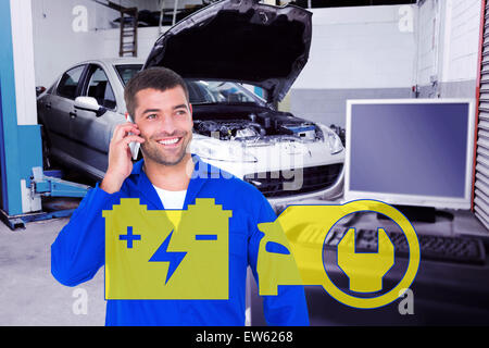 Composite image of smiling male mechanic using mobile phone Stock Photo