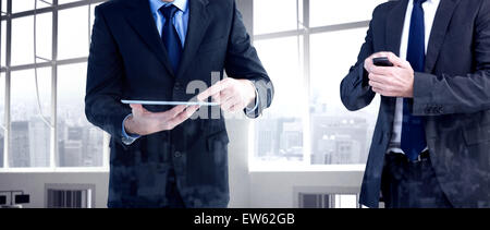 Composite image of focused businessman texting on his mobile phone Stock Photo