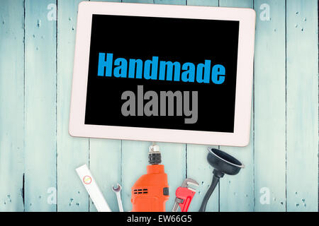 Handmade against tools and tablet on wooden background Stock Photo