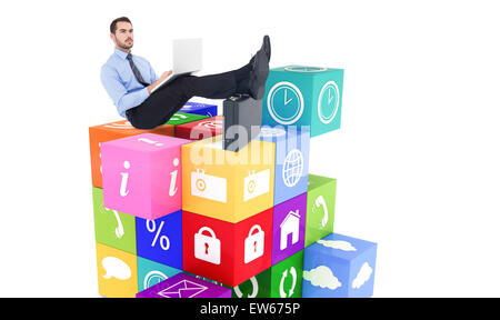 Composite image of businessman sitting on the floor with feet up on suitcase Stock Photo