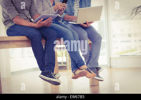 Three creative business team working on electronic devices Stock Photo