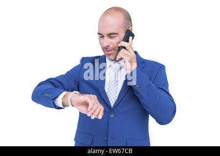 businessman talking on the phone and looking at his watch Stock Photo