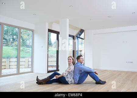 Happy Young Couple Sitting On Floor In New Home Stock Photo
