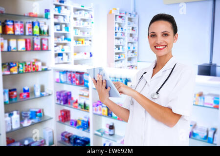 Composite image of pretty nurse using tablet pc Stock Photo