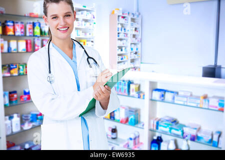 Composite image of happy doctor writing on clipboard Stock Photo