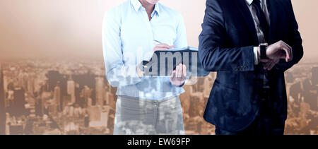 Composite image of handsome businessman checking the time Stock Photo