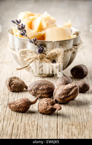 shea nuts with a cup of shea butter. Shallow depht of field Stock Photo