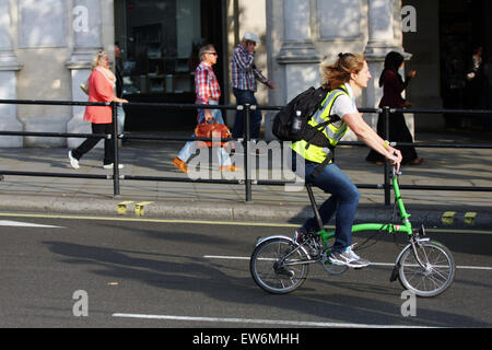 A female riding a folding bicycle towards Trafalgar Square in London, England Stock Photo