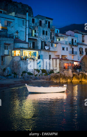 A boat at night in Cefalu, Italy. Stock Photo