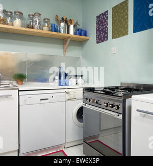 Stainless steel range oven with dishwasher and washing machine in economy style nineties kitchen