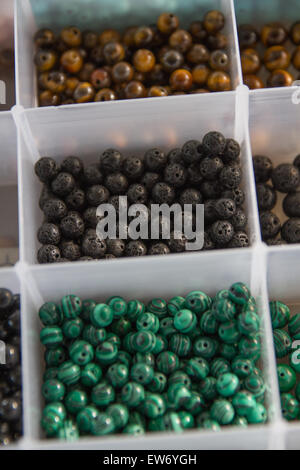 colored beads pearls stones in separated in plastic containers for craft artistic jewels. Stock Photo