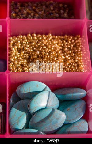 colored beads pearls stones in separated in plastic containers for craft artistic jewels. Stock Photo