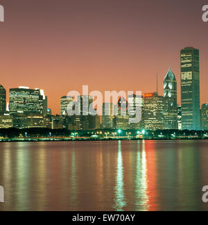 High rise office blocks lit at night in the city of London, viewed from across the River Thames Stock Photo