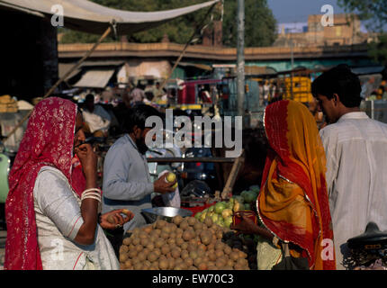 Woman wearing saris buying from a stall holder in an Indian street market         FOR EDITORIAL USE ONLY Stock Photo