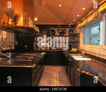 Black fitted units in large modern kitchen in Spanish villa Stock Photo